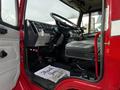Interior view of a red 1994 Freightliner FL80 featuring the driver's seat dashboard steering wheel and controls