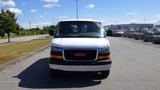 A white 2015 GMC Savana van with a black grill and red GMC logo facing forward