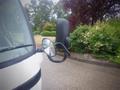 A 2003 Toyota Toyoace showing the side mirror and door with rain droplets on the mirror