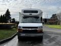 A white 2015 Chevrolet Express van with a rounded roof and front grille featuring the Chevrolet emblem