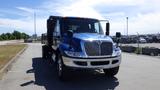 A blue 2012 International DuraStar 4300 truck with a chrome front grille parked on a road facing forward