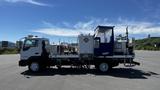 A 2006 Ford LCF 550 truck equipped with industrial equipment and a blue enclosed area on the cargo bed