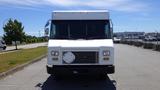 A white 2011 Ford Econoline van with a flat front and rectangular headlights parked in an open area