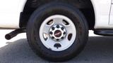 A close-up view of a 2015 GMC Savana wheel featuring a silver alloy rim with GMC logo and a Goodyear Wrangler tire