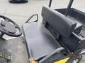 A black bench seat of a 2000 Ez-go Industrial 800 with a textured surface and a backrest attached to a utility vehicle