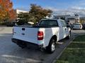 A white 2008 Ford F-150 XL with a standard cab and a black bed liner viewed from the rear angle