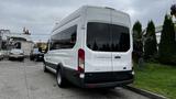 A white 2017 Ford Transit van with large windows and a high roof parked on a concrete surface