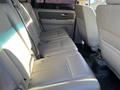 The interior of a 2013 Ford Expedition showing gray leather bench seats in the second row with seat belts visible