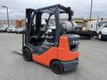 2011 Toyota Forklift with an orange and gray body featuring a driver’s seat and a large gas tank mounted on the back