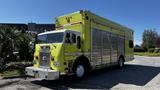 A bright yellow 1995 Freightliner FLL086 truck with chrome accents and a large cargo area on the back