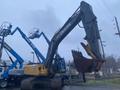 A 2014 John Deere 350G excavator with a large bucket attachment standing on a construction site