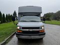 A 2015 Chevrolet Express with a large, boxy body and a prominent front grille featuring the Chevrolet emblem