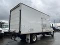 A white 2008 Hino Conventional Cab truck with a large box trailer featuring some graffiti on the side