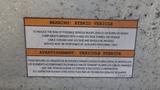 A label on a 2011 Ford Econoline clearly stating it is a hybrid vehicle with warnings about high voltage components and service instructions for qualified personnel