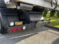 The rear of a 2011 International 7500 truck featuring red and white lights a black bumper and visible hitch connections