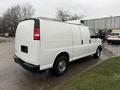 A white 2009 Chevrolet Express cargo van parked with a high roof and dual rear doors