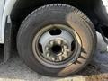 Close-up of a tire and wheel of a 2015 Chevrolet Express with visible bolts and a Michelin tire tread design