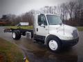 A 2006 International 4300 truck with a white cab and a chassis designed for cargo or towing without a cargo box. The truck features chrome side mirrors and an exposed engine compartment.