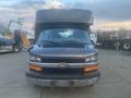 A black 2017 Chevrolet Express van with a prominent front grille and headlights visible, featuring a cargo-style area on top