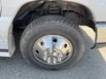 Close-up of a chrome wheel with lug nuts on a 2012 Ford Econoline tire showing tread pattern and wheel design