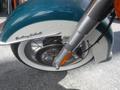 Close-up of the front wheel and fender of a 2009 Harley-Davidson Flstc with a white wall tire and chrome details