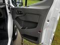 A close-up of the driver's side door panel of a 2021 Ford Transit showing the handle and storage compartment