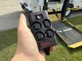 A hand holding a black Ricon remote control with four buttons labeled power off on and directional arrows for up and down
