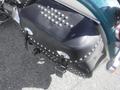 A black leather saddlebag with silver studs and chrome accents attached to a motorcycle