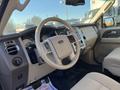 Interior view of a 2013 Ford Expedition with a leather-wrapped steering wheel dashboard and control panel showing various gauges and air vents