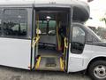 A 2017 Chevrolet Express with an open side door showcasing a wheelchair accessibility ramp and interior seating