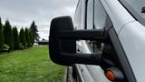 A 2017 Ford Transit with a side mirror prominently displayed in the foreground