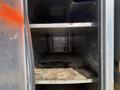Interior of a 2010 Ford F-550 showing empty shelves inside a storage compartment with visible dirt and wear on the surfaces