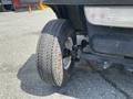 A close-up of a tire from a 1999 Ez-go Industrial vehicle showing a textured tread pattern and a worn appearance