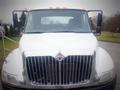 Front view of a white 2006 International 4300 truck featuring a large chrome grille and orange roof lights