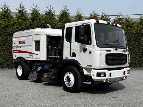 2012 Autocar Xpert street sweeper with a white body and red accents featuring a large cleaning unit attached to the rear and specialized brushes for road maintenance