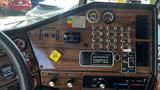 Dashboard of a 1995 Freightliner FLL086 featuring various gauges switches and controls on a wood-like panel