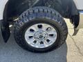 Close-up of a chrome wheel with five spokes and black rugged tire tread on a 2019 Ford F-350 SD