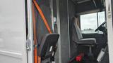 A 2006 Ford Econoline with a driver's seat and an empty seat next to it both featuring gray upholstery and an orange safety belt