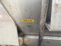 A yellow sticker labeled "GREASE" attached to a metal surface on a 2010 Ford F-550