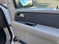 Interior door panel of a 2013 Ford Expedition featuring the window controls and armrest area in a light gray color scheme