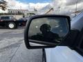 A side mirror of a 2017 GMC Sierra 1500 reflecting a blurred image of the driver