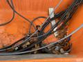 A collection of tangled cables and wires with some fallen leaves in an orange compartment of a 2008 Fassmer 20 Foot Fast Rescue boat