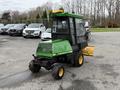 A 1994 John Deere F1145 compact utility vehicle with a snow plow attachment and enclosed cab in green and black color scheme