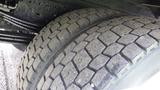 Close-up of the tires of a 2016 Hino 195 showcasing their tread patterns and rugged design