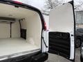 A 2009 Chevrolet Express van with an open cargo area featuring a clean interior and a partially closed side door