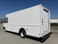 A white 2011 Ford Econoline cargo van with a rear roll-up door and no visible markings on the side