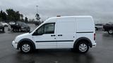 A 2012 Ford Transit van in white with a side view showcasing sliding doors and a light bar on the roof