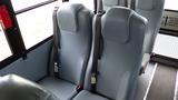 Two padded seats with seatbelts inside a bus interior