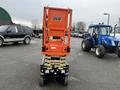 2024 JLG R1932 scissor lift in orange and black with a raised platform and wheels positioned on a parking lot surface