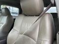 Interior view of a 2010 Dodge Ram featuring a tan leather seat with a Ram logo embossed on the headrest and a seatbelt partially visible attached to the side